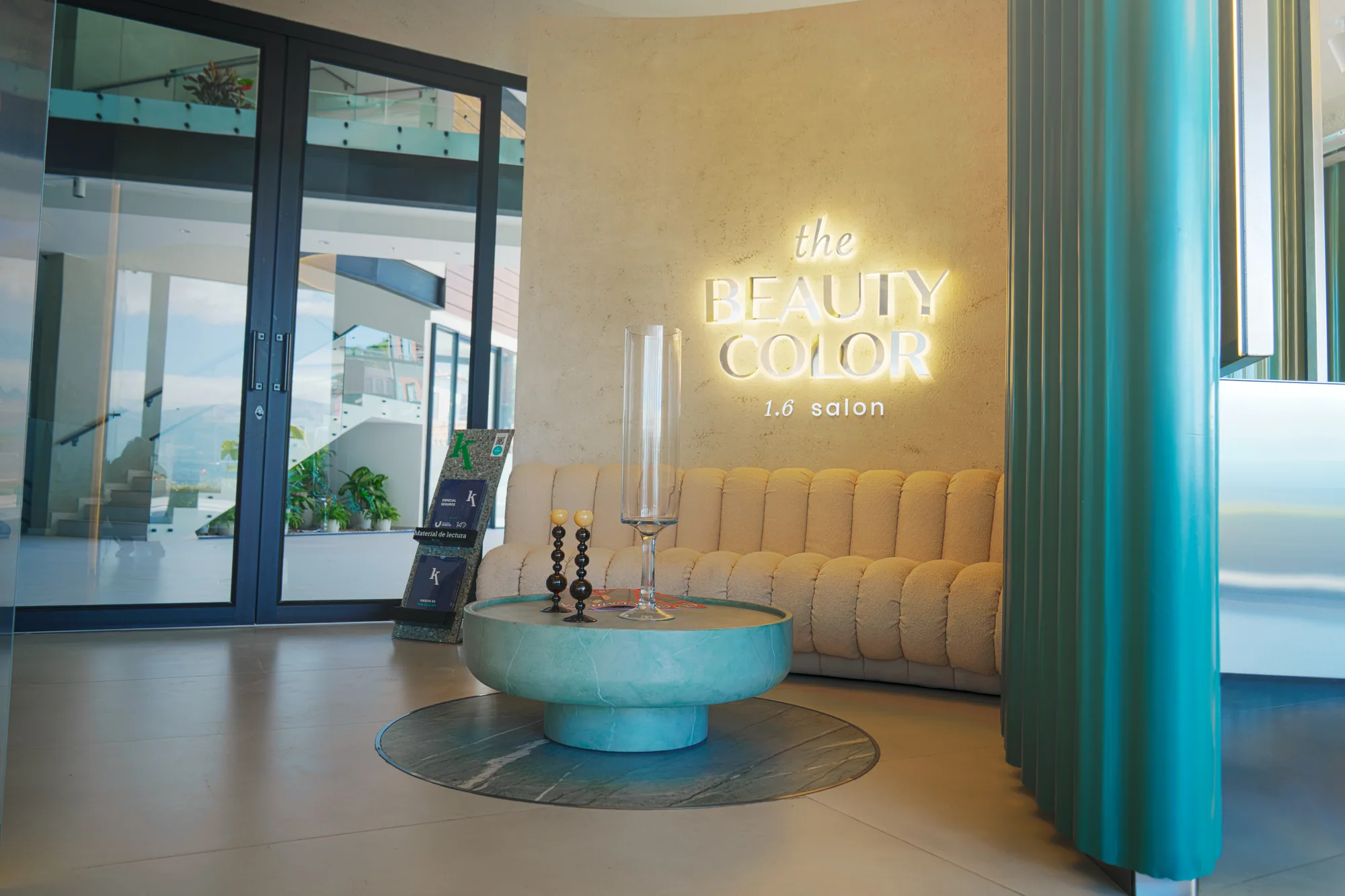 Recepción del salón, con sofá claro y el logotipo de The Beauty Color.